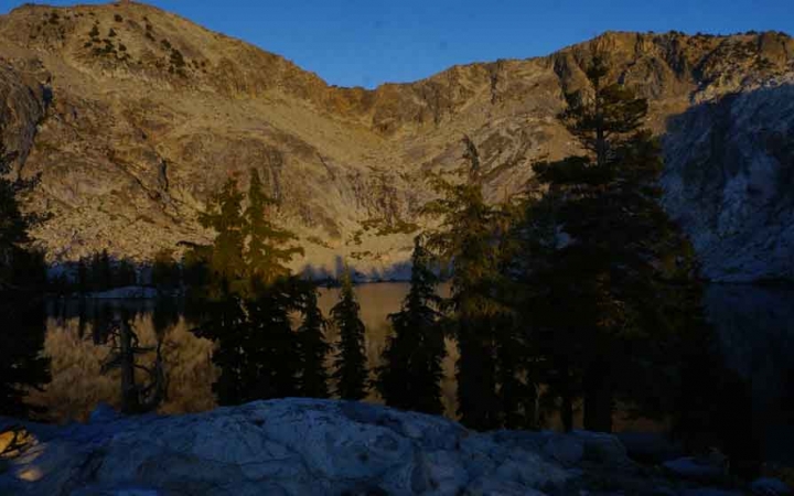 a body of water lies among trees and hills in yosemite